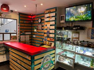 a store with a red counter and a fish aquarium at Mandala Yoga Hostel in Bogotá