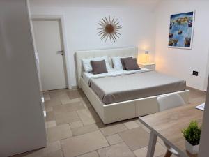 a bedroom with a white bed and a table at Maison Palmieri in Gallipoli
