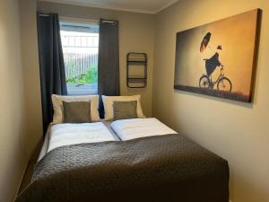 a bedroom with a bed and a picture of a bike at g-Suites in Tromsø