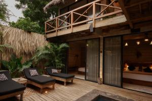 ein Haus mit einer Terrasse mit Stühlen und einem Balkon in der Unterkunft Punta Tamarindo in Puerto Escondido