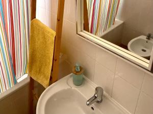 a bathroom with a sink and a mirror at Casa do Cisne in Porto Santo +15 photos