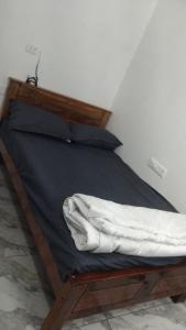 a bed with a wooden frame with a blanket on it at S ROOMs in Pithāpuram