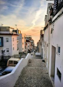 a street in a city with buildings and cars at Beach And Mountain Apartment in Sesimbra