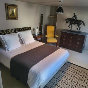 a bedroom with a bed and a horse statue on a dresser at Le Figuier, Appartement centre d'Etretat avec balcon in Étretat