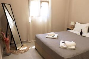 a bedroom with a bed with towels on it at STV Royal Apartments 3 in Areopolis