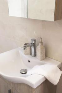 a bathroom sink with a faucet and a towel at STV Royal Apartments 3 in Areopolis