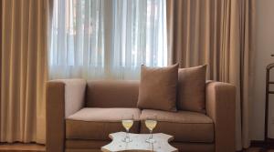 two wine glasses on a table in front of a couch at Hotel Portal del Angel in Tegucigalpa