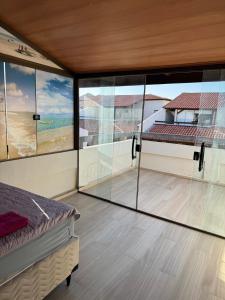 a bedroom with glass walls and a bed in a room at Casa Lençóis Maranhenses in Barreirinhas