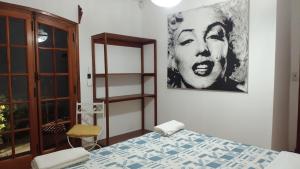 ピナマールにあるLa casa más alta de Pinamarのベッドと壁に絵が飾られた寝室