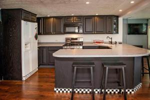 een keuken met zwarte kasten en een groot eiland met barkrukken bij Shore Thing in Hammondsport +12 foto's