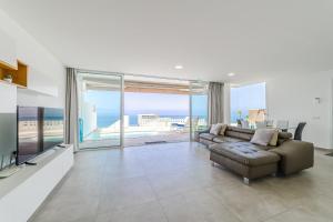ein Wohnzimmer mit Couch und Blick aufs Meer in der Unterkunft Fabuloso Bungalow con Vista Panorámica y Piscina Privada. in Acantilado de los Gigantes