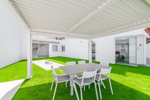 ein Esszimmer mit grünem Gras und einem Tisch und Stühlen in der Unterkunft Fabuloso Bungalow con Vista Panorámica y Piscina Privada. in Acantilado de los Gigantes