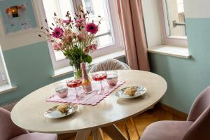 una mesa con copas de vino y un jarrón de flores en Chopin, en Leipzig