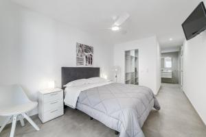 ein weißes Schlafzimmer mit einem Bett, einem Schreibtisch und einem TV in der Unterkunft Fabuloso Bungalow con Vista Panorámica y Piscina Privada. in Acantilado de los Gigantes + 38 Fotos