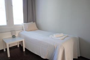 a bedroom with a bed with a table and a window at Near Santa Village with Free Parking in Rovaniemi