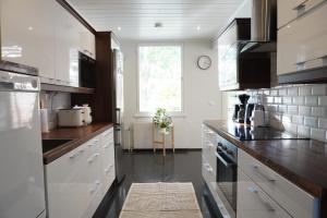 a kitchen with white appliances and a large window at Near Santa Village with Free Parking in Rovaniemi