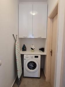 a white washer and dryer in a small room at Gjiri I Lalzit apartament in Draç