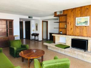 un soggiorno con mobili verdi e camino di La Nogalera Experience a Torremolinos