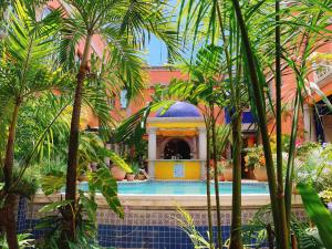 a courtyard with a pool in a building with palm trees at Hotel Portal del Angel in Tegucigalpa
