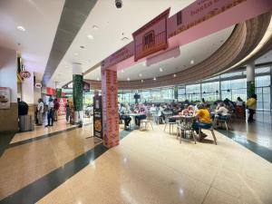a group of people sitting at tables in a shopping mall at Laureles Boutique Stay in Medellín
