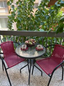 a table and two chairs with a bowl of fruit on a balcony at Petaluda House 3 in Athens