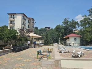 una piscina con mesas y sillas junto a un edificio en Badam Hotel, en Ganja