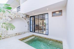 an indoor pool in a house with a window at 1BR Balcony Pool Villa Near Seseh Beach in Munggu