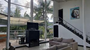 a living room with a couch and a large window at Casa de Campo PREMIUN in Guatapé +15 photos
