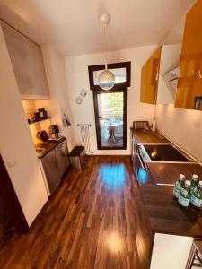 ケルンにあるZentrales Apartment in Köln Deutzのウッドフロアのキッチン、大きな窓が備わります。 +2枚の写真