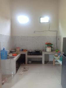 KinatiにあるAssyifa Homestayのキッチン(テーブル2台付)