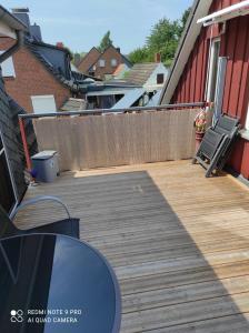 eine Veranda mit einer Holzterrasse mit einem Zaun in der Unterkunft Haus Sonnenschein in Heikendorf