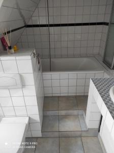 ein weißes Badezimmer mit Badewanne und Waschbecken in der Unterkunft Haus Sonnenschein in Heikendorf