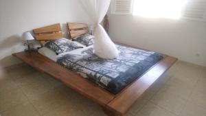 a wooden bed in a room with at F2 pour une pause hors du temps in Ducos