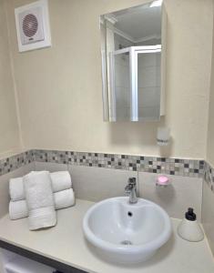 プレトリアにある1 bed Apartment in hatfieldの洗面台、鏡、タオルを備えたバスルーム