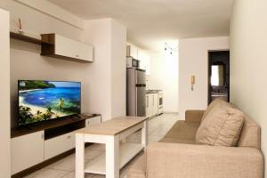 a living room with a couch and a tv on a wall at departamento 4 y 59 in La Plata