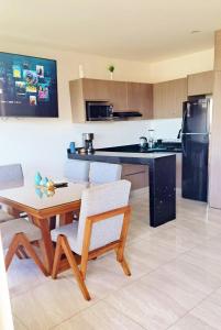 a kitchen with a table and chairs and a refrigerator at Marina Cerritos de Lujo - Azul Cielo - 5 Albercas in Mazatlán