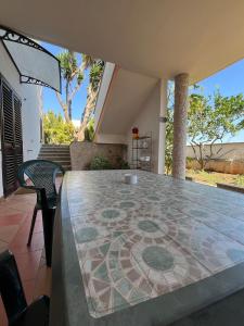 a patio with a table with a mosaic floor at Ílios Apartment in Diso