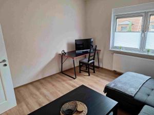 a living room with a desk with a computer in it at Ferienwohnung Missionshausstrasse in Sankt Wendel