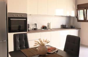 a kitchen with a table with two chairs and a counter at Stv Royal Appartments in Areopoli +8 photos