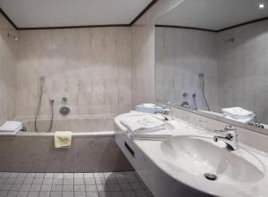 
a bathroom with a sink, toilet and bathtub at Post-Hotel in Mittenwald
