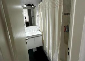 a bathroom with a sink and a shower with a mirror at departamento 4 y 59 in La Plata +2 photos