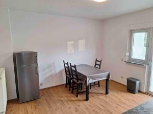 a dining room with a table and a refrigerator at Ferienwohnung Missionshausstrasse in Sankt Wendel +3 photos