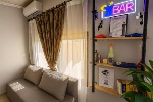 a couch sitting in front of a window with a bar sign at My Summerhouse with jacuzzi in Kremasti