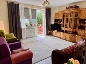 a living room with a couch and a tv at Kolobrzeska PRL Apartment with modern touch in Białogard