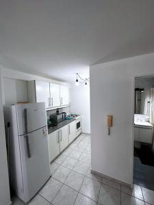 a kitchen with white cabinets and a white refrigerator at departamento 4 y 59 in La Plata