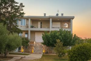 a large house with a staircase in front of it at Mulberry House by the Sea Νέα Μάκρη in Nea Makri