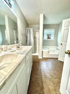 a white bathroom with two sinks and a shower at Spacious Oasis 15 Minutes from Atlanta Airport in Jonesboro
