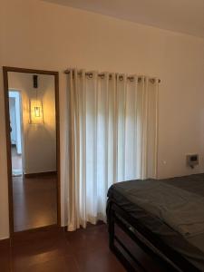 1 dormitorio con cortinas blancas, espejo y cama en Country Side Inn, en Vayittiri