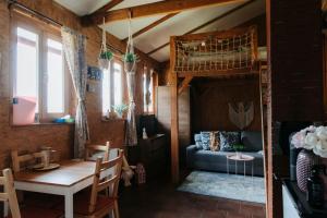 a living room with a loft bed and a table at Apartmán na Ranči pod Lovošem in Velemín