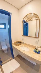 a bathroom with a sink and a mirror at Pousada Vila Pequi in Barreirinhas